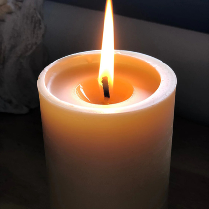 Pure beeswax pillar candle, with a pure cotton wick, burning with a dark background. Stocked at LOVINLIFE Co Byron Bay for all your gifts, candles and interior decorating needs
