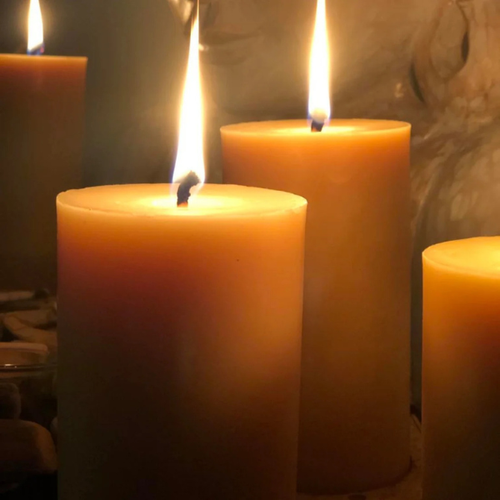 Three lit  pure beeswax pillar candles, with a pure cotton wicks, a warm glow against a blurred background. Stocked at LOVINLIFE Co Byron Bay for all your gifts, candles and interior decorating needs