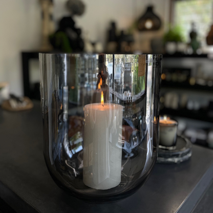 Round Base Candle Holder / Vase from Francalia in Lustre Black, pictured in foreground holding large white pillar candle, with the shop in the background - Stocked at LOVINLIFE Co Byron Bay for all your gifts, candles and interior decorating needs