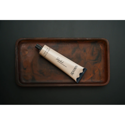 Lovinlife Co ByronBay – Saarde Istanbul hand and body moisturiser – clove, cinnamon, lemon, geranium, sandalwood and oak moss scents – pictured as flat lay moisturiser tube in resin dish - available at LOVINLIFE Co Byron Bay for all your gifts, candles and interior decorating needs