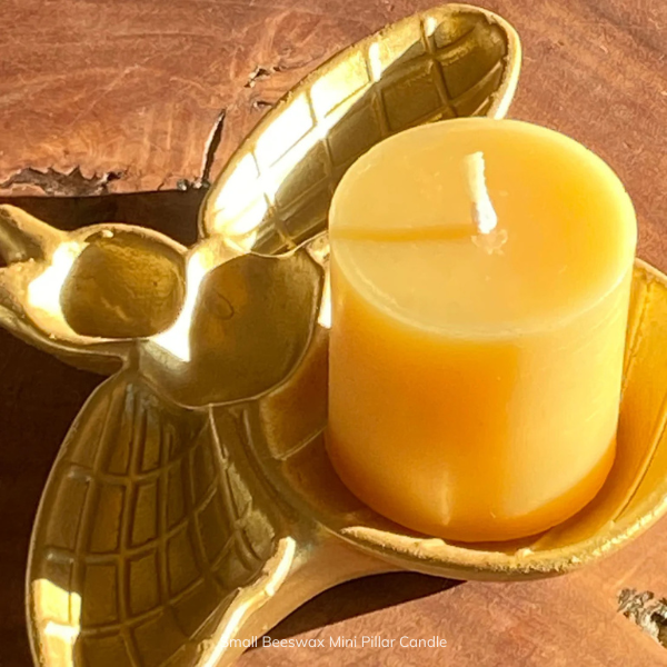 Pure Beeswax mini pillar candle in a decorative gold holder shaped like a bee on a wooden surface. Stocked at LOVINLIFE Co Byron Bay for all your gifts, candles and interior decorating needs