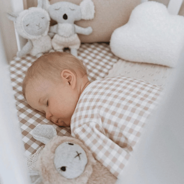 Soft Toy Koala called Bernard, sitting next to a sleeping baby in a crib, made from beautifully soft wool-blend fabric with the cosiest cream knitted pants in Australian merino wool - Available at LOVINLIFE Co Byron Bay