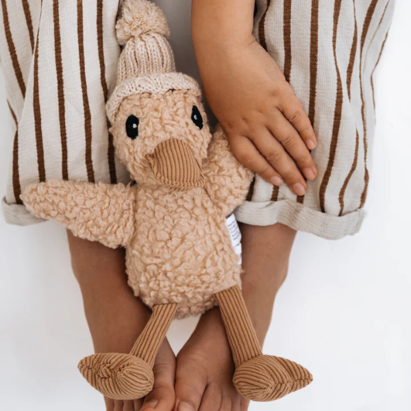 Child wearing striped pants holding a Soft Toy Duck made from our unique cotton plush fabric with caramel corduroy accents and Australian merino wool knitted beanie - Duck Edmond - Available at LOVINLIFE Co Byron Bay