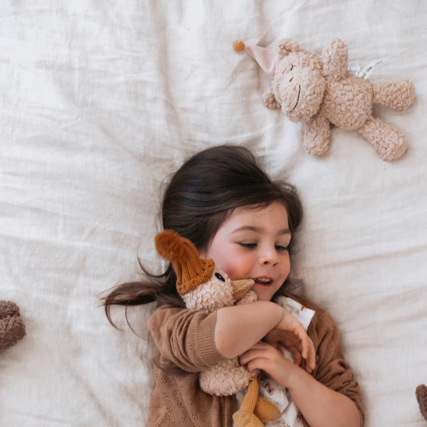 Girl lying on her bed hugging her Soft Toy Duck made from a unique cotton plush fabric with caramel corduroy accents and Australian merino wool knitted beanie - Duck Petunia - Available at LOVINLIFE Co Byron Bay