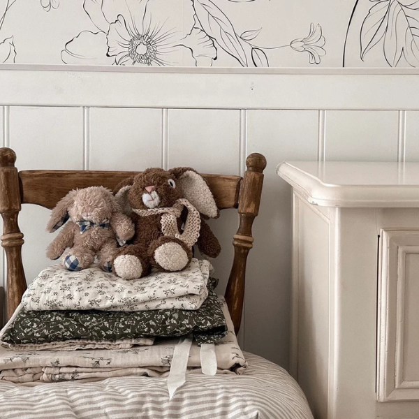 Two soft stuffed toys sitting on blankets folded on a chair. The Soft Toy Rabbit is made from a unique Vanilla cotton plush fabric with dapper blue gingham bow tie - Rabbit Louis - Available at LOVINLIFE Co Byron Bay