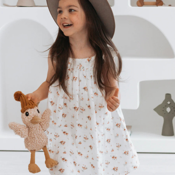 Girl in floral dress carrying her Soft Toy Duck made from a unique cotton plush fabric with caramel corduroy accents and Australian merino wool knitted beanie - Duck Petunia - Available at LOVINLIFE Co Byron Bay