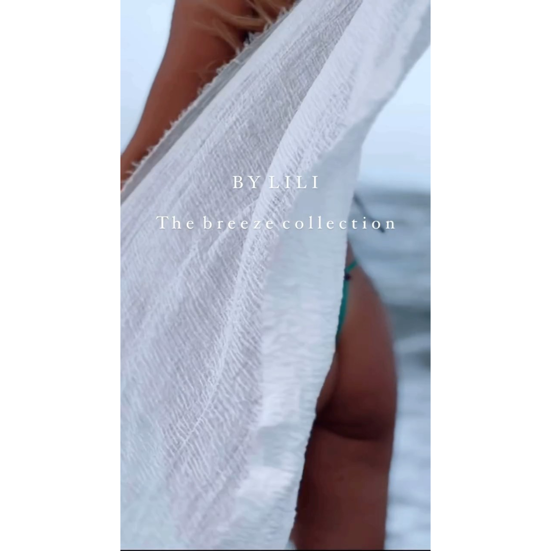 The Breeze Sarong – a soft, lightweight cotton sarong in black, white and sand – White cotton sarong pictured floating in the wind - Stocked at LOVINLIFE Co Byron Bay for all your gifts, candles, homewares and interior decorating needs