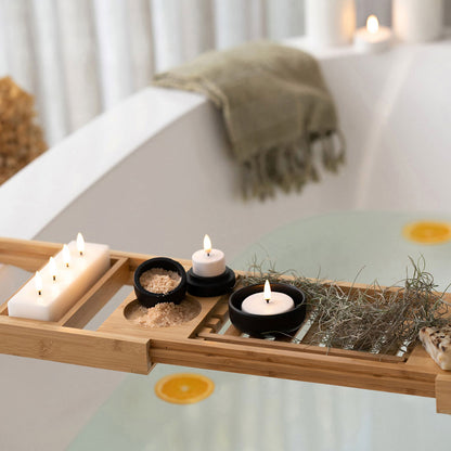 Battery Operated LED Tea Light Candles - UYUNI. Made from Nordic White wax to look and feel real, these hand-crafted battery operated luxury flameless candles are all remote enabled, with timer and dimmer options, allowing you to personalise every occasion. tea light candles pictured in resting on a bath caddy. Stocked at LOVINLIFE Co Byron Bay for all your gifts, candles, homewares and interior decorating needs