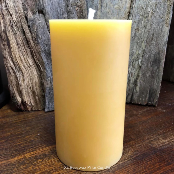 XL pure beeswax pillar candle with pure cotton wick on a wooden surface with a rustic background. Stocked at LOVINLIFE Co Byron Bay for all your gifts, candles and interior decorating needs