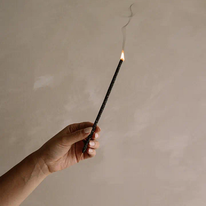 Cedar and Myrrh Black Copal Hand Rolled Incense Stick - alight, being held up - Stocked at LOVINLIFE Co Byron Bay for all your gifts, candles and interior decorating needs