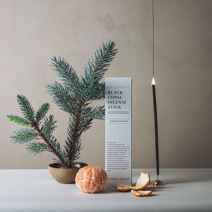 Cedar and Myrrh Black Copal Hand Rolled Incense Stick - pictured alight with box, peeled mandarin and fir tree branch - Stocked at LOVINLIFE Co Byron Bay for all your gifts, candles and interior decorating needs