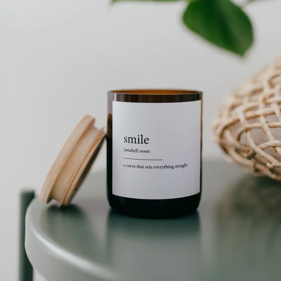 Commonfolk Dictionary Candle - Smile - amber glass jar on table with wood lid on side - Stocked at LOVINLIFE Co Byron Bay for all your gifts, candles and interior decorating needs